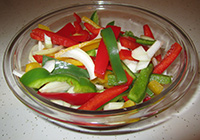 Bowl of sliced peppers and onions
