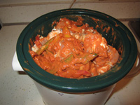 Crock pot with chicken and peppers in it